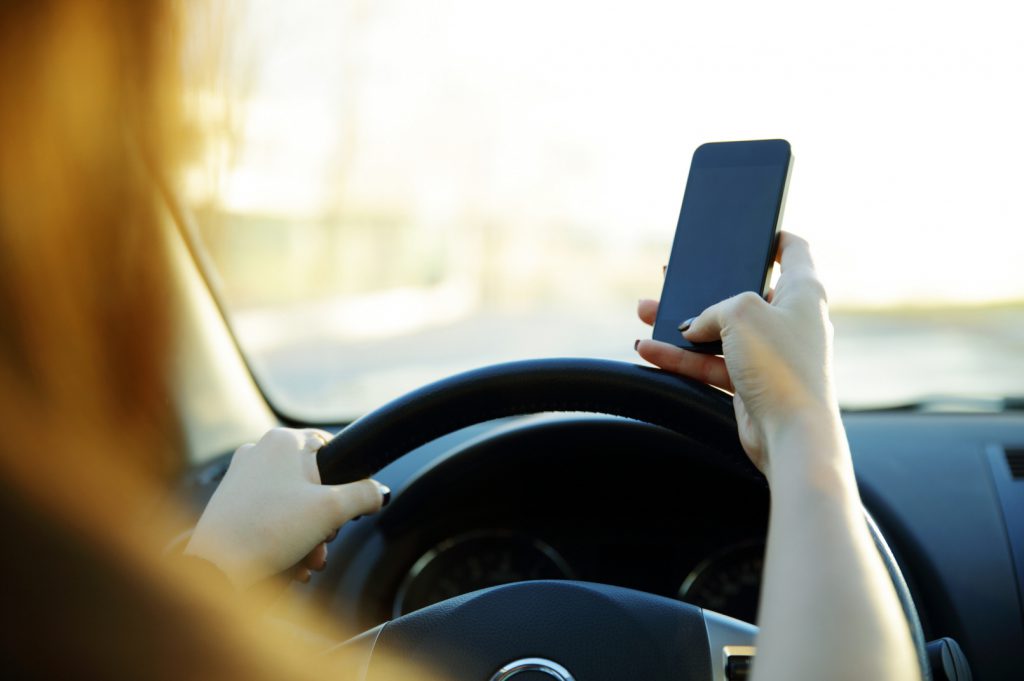 Close-up of a businesswoman sending a text while driving to work
